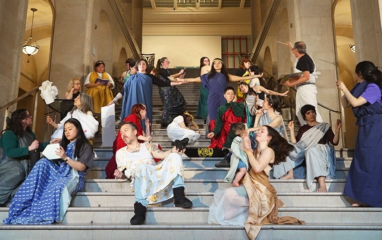 People in various poses on the steps of an auditorium 