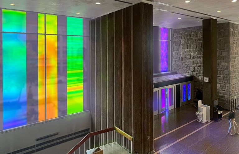 Lobby of a large building with brightly coloured tinted glass windows
