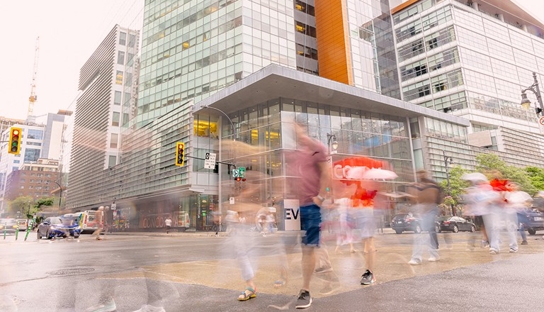 Photo with motion blur of people walking in a city setting.