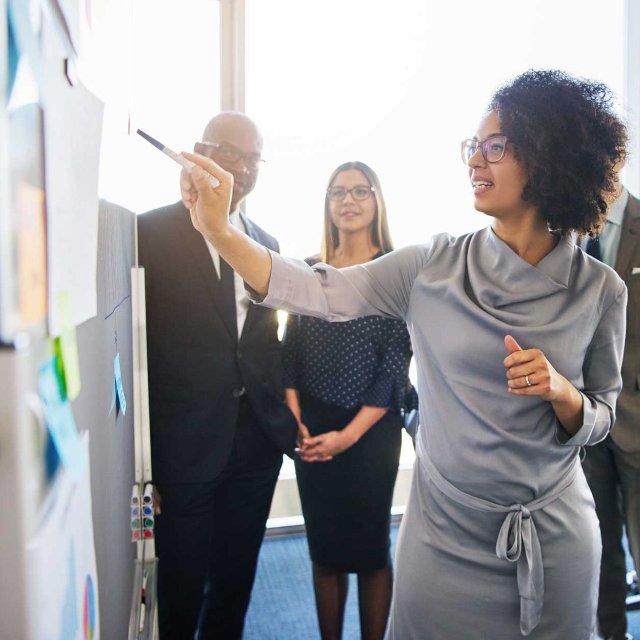 Woman gives presentation to three other professionals