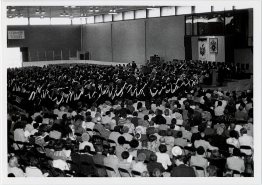 Auditorium with divided seating between guests and people dressed in graduation ceremony