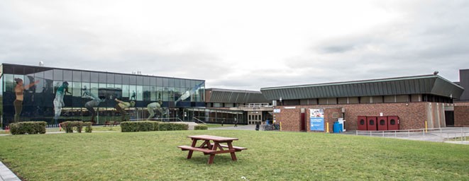Grass quad connecting various buildings with a picnic table in the middle
