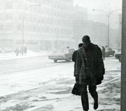 Person walking outside through a snowstorm next to the Hall Building
