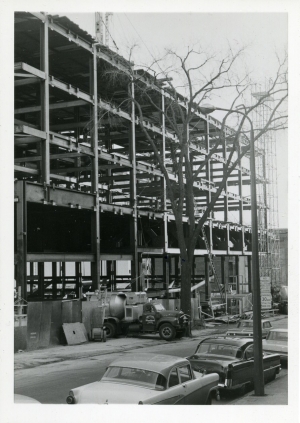 Metal scaffolding of the Hall building exposed during construction with a truck at the entrance