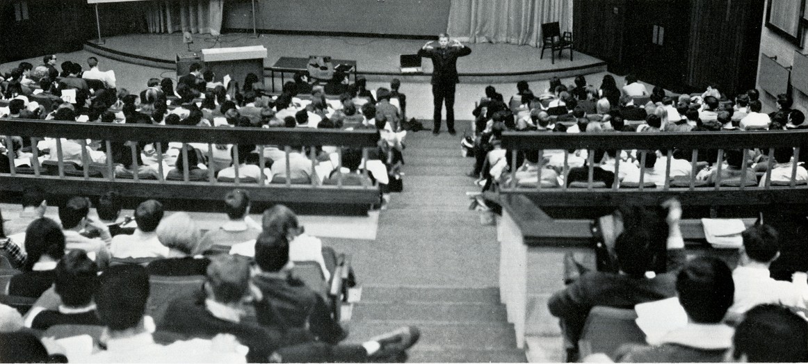 Students sitting in auditorium looking towards instruction at the front