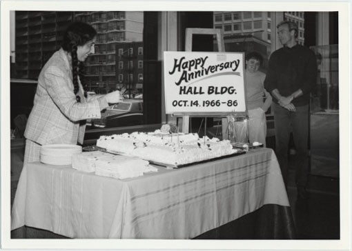 Person giving away cake for the 20th Anniversary of the Hall Building