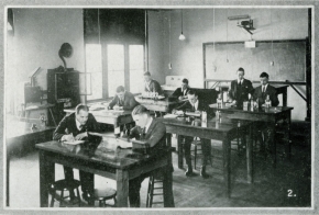 Old black and white photo of men in a classroom working in groups from Loyola College Review, 1923
