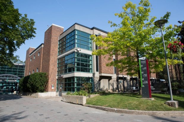 Exterior view of the Vanier Extension (VE) Building on Concordia’s Loyola Campus, showing a brick and glass façade surrounded by trees and pedestrian pathways.
