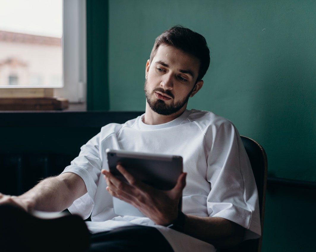 male student reading a pdf on a tablet