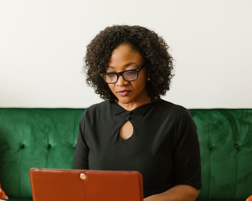 a professor who is a woman of color typing in her computer