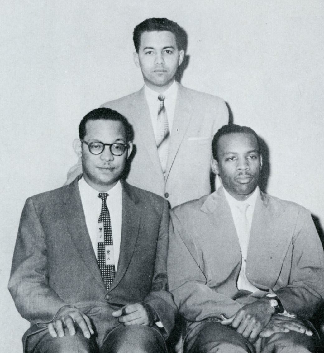 Three men in suits, posing for a photo.