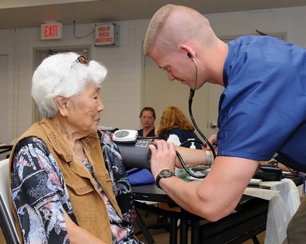 A nurse measuring a senior woman's blood pressure