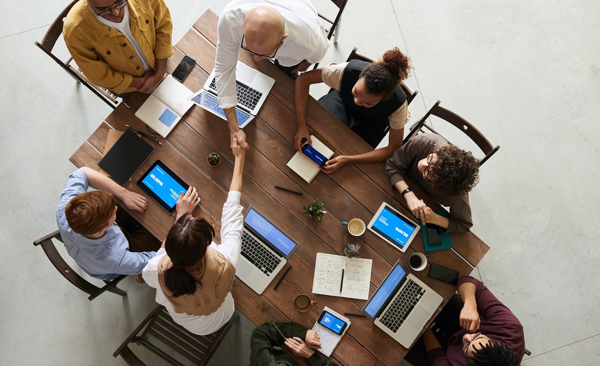 A group of people working with laptops around a table