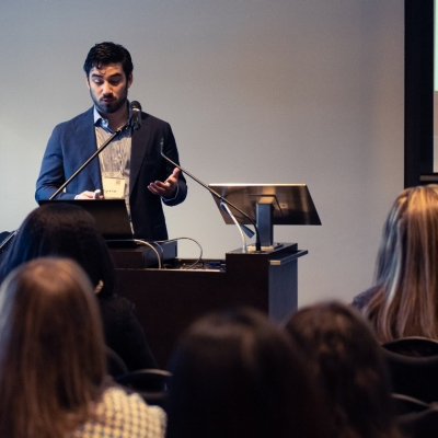 A speaker presents his research at CCRH's conference as students listen