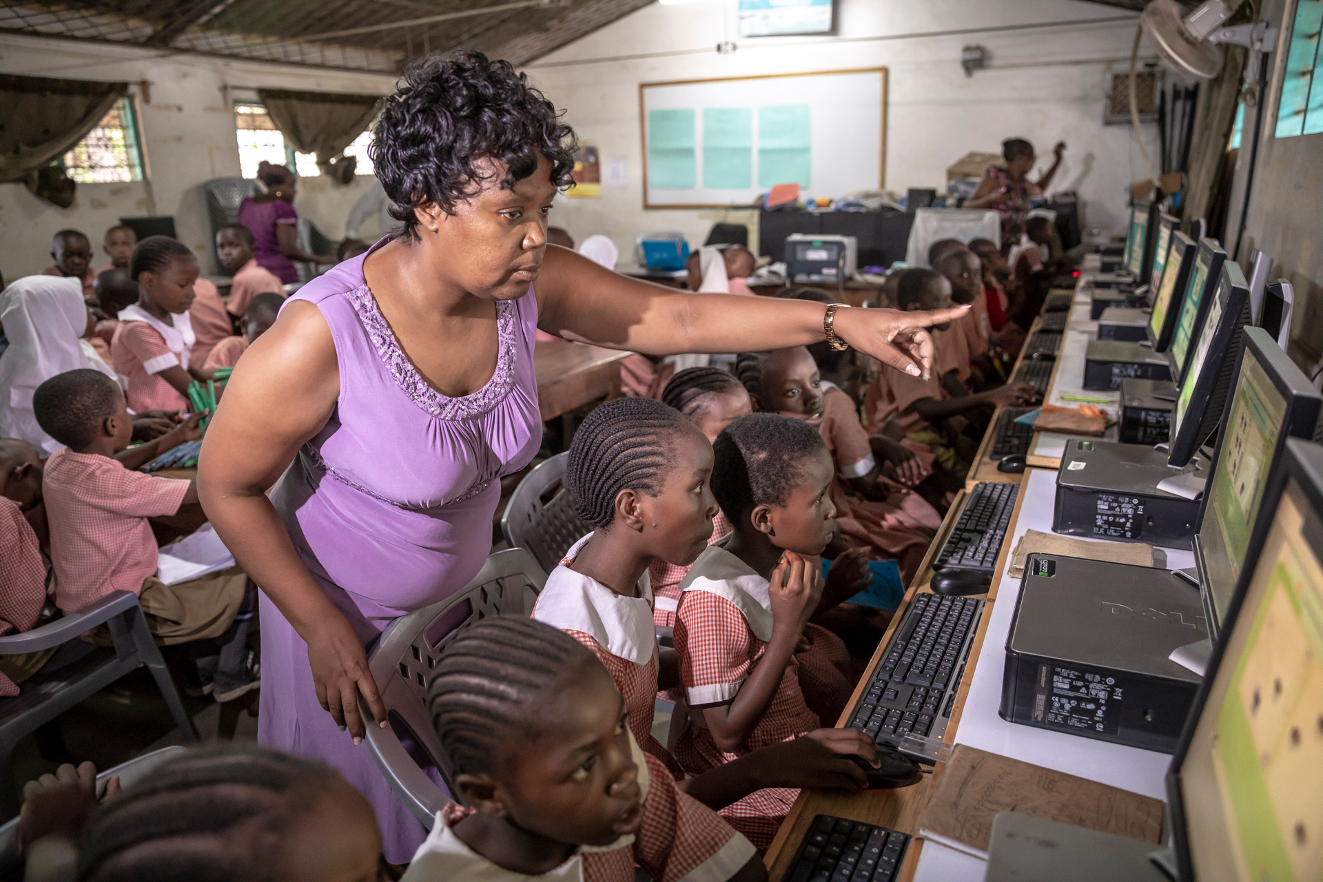 Teacher supervising students at computers