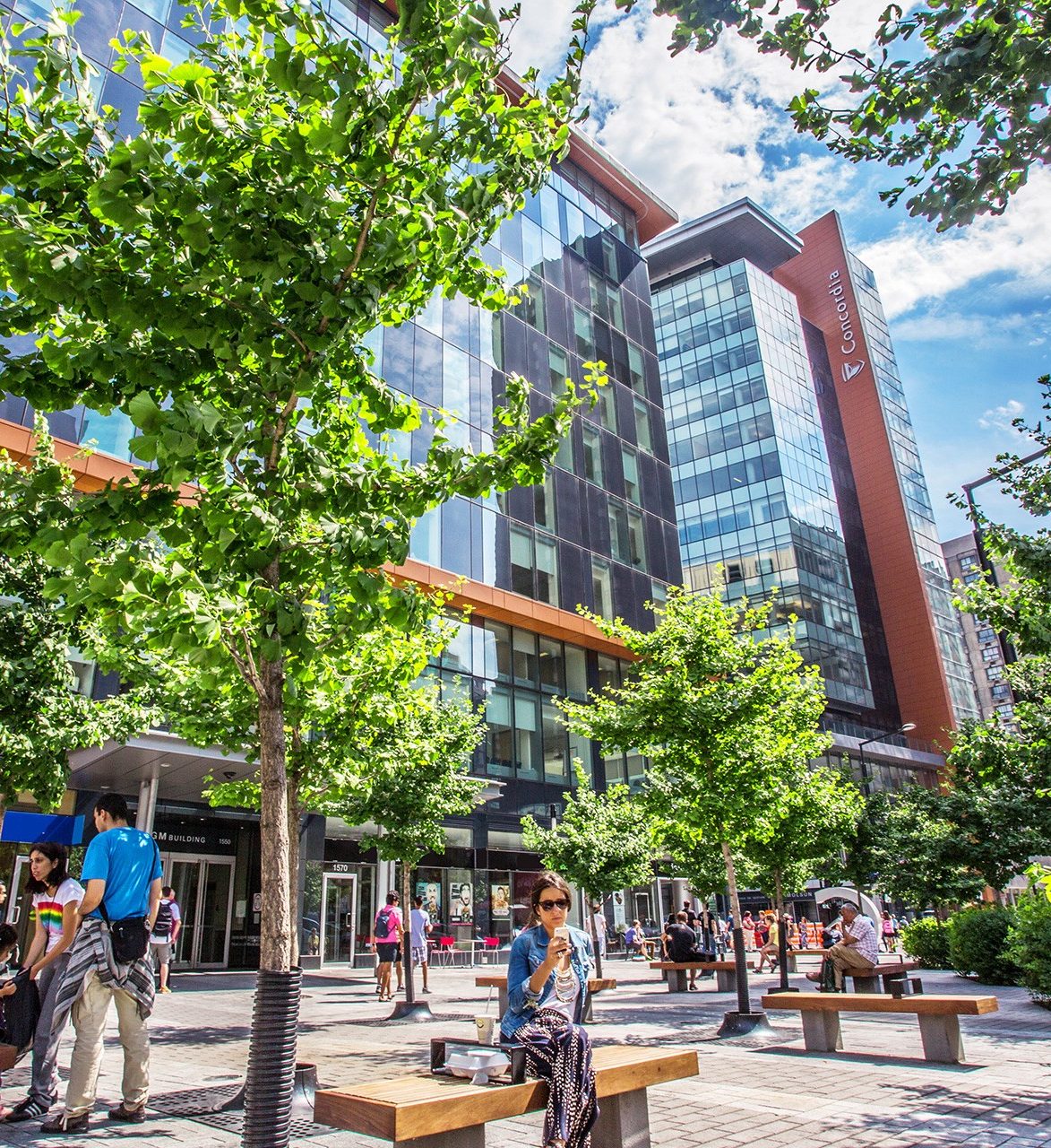 People outside Concordia University's Guy-De Maisonneuve Building on the Sir George Williams Campus enjoying a sunny day