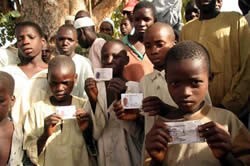 Underage voters brandish their voting cards during the 2007 elections.  IRIN