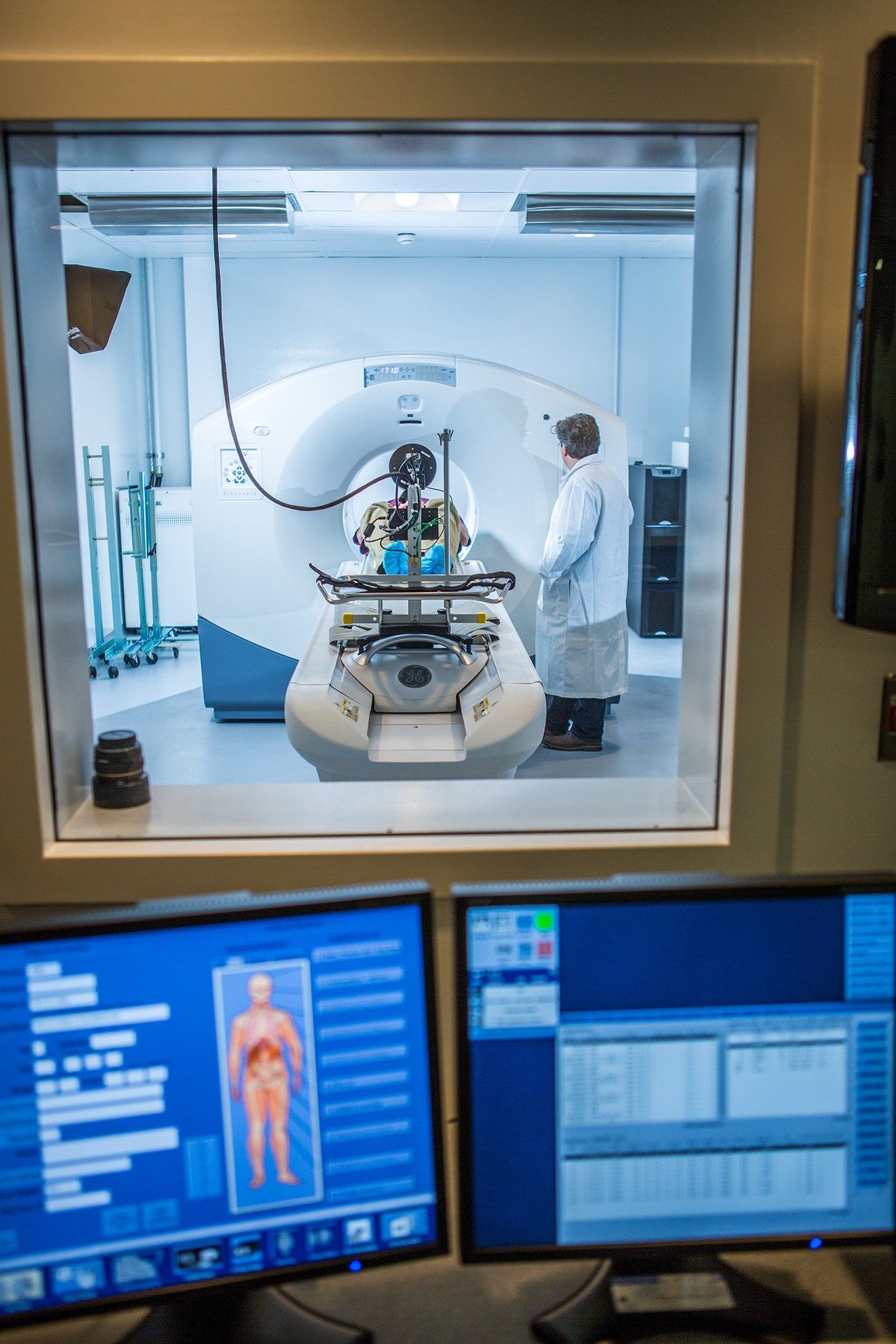 A researcher monitors a participant undergoing a PET-CT scan