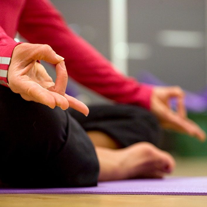 a person seated cross-legged with fingers in meditation pose