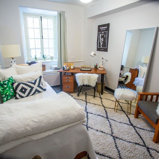A bright cozy furnished bedroom in the Grey Nuns residence with a large window