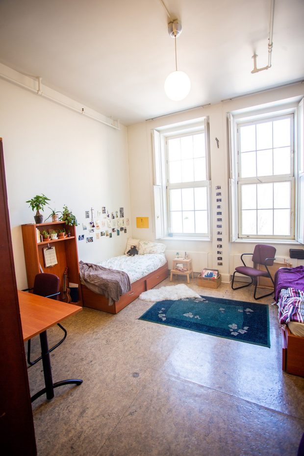 A bright and airy large, shared, double-room at the grey Nuns residence filled with basic student furniture.