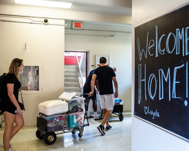 Concordia students pull loaded hand trucks through the hall as they move into residence