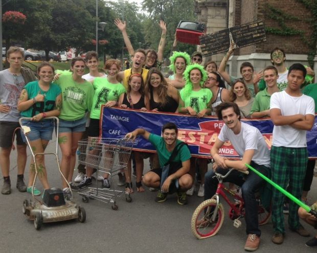 A group of happy Concordia students wearing green for a residence activity outdoors