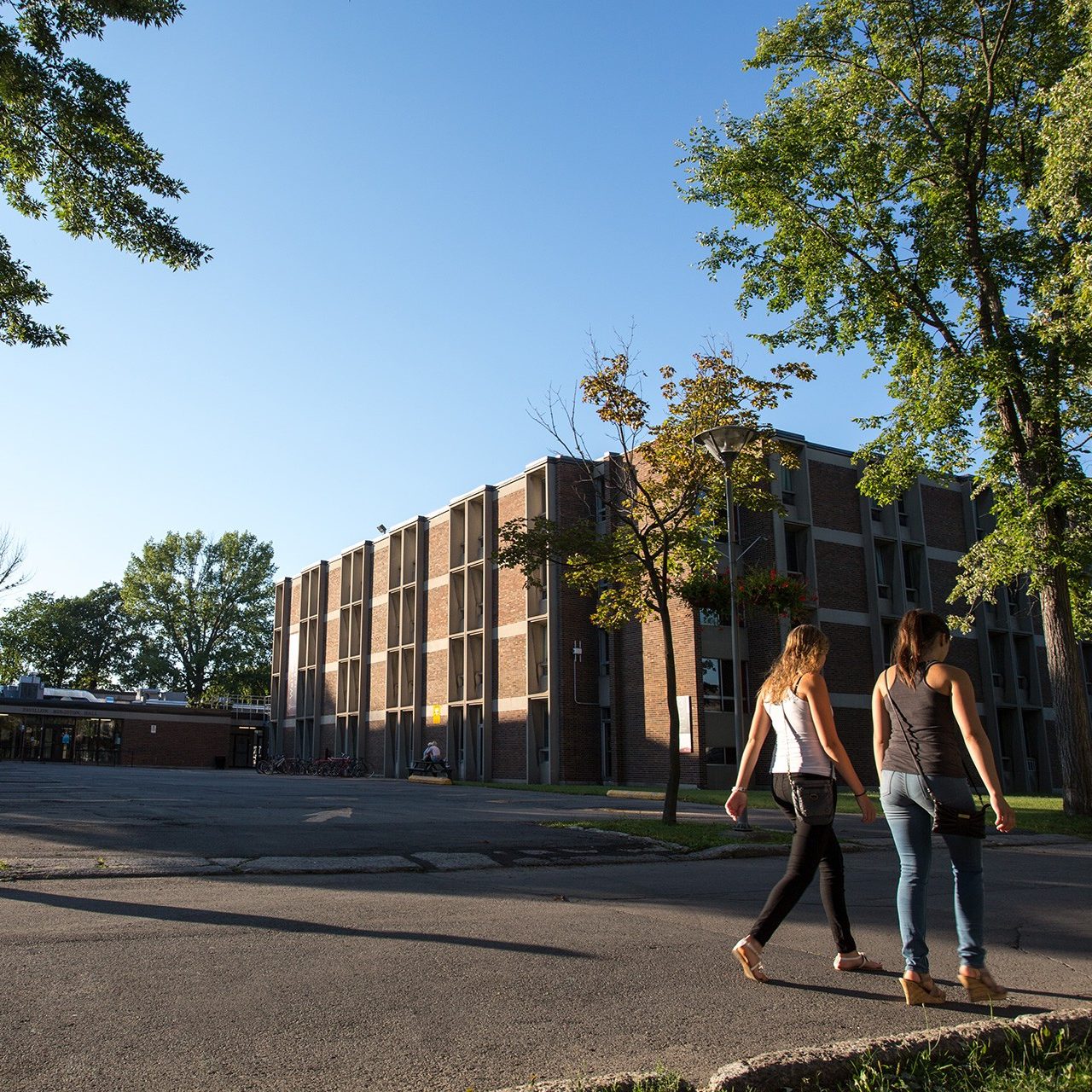 Two young women stroll past a building on Concordia University's Loyola Campus