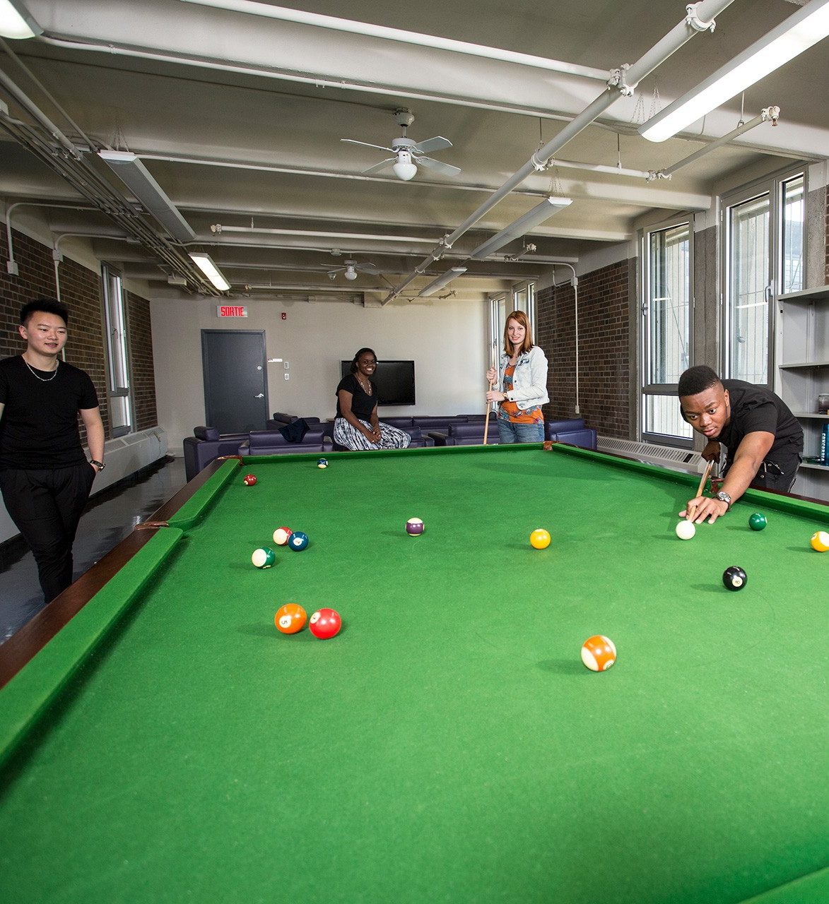 Concordia students play pool in a residence games room
