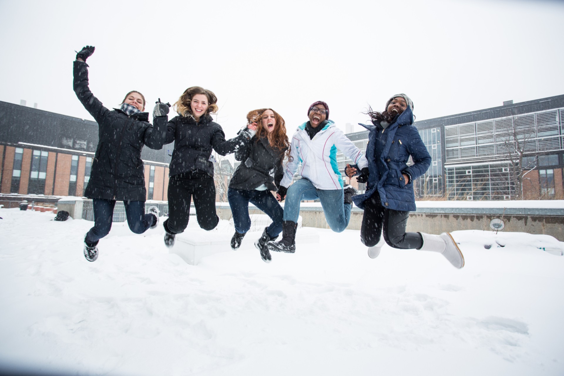A group of students cheerfully jumping at the same time for the camera at Loyola campus
