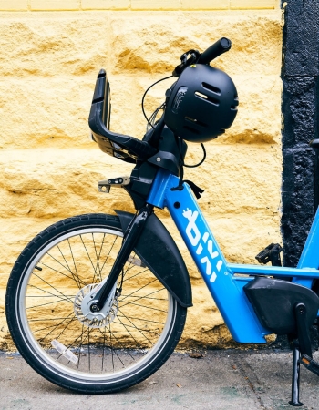 A blue BIXI bike against a yellow wall