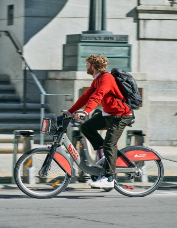 A blue BIXI bike against a yellow wall