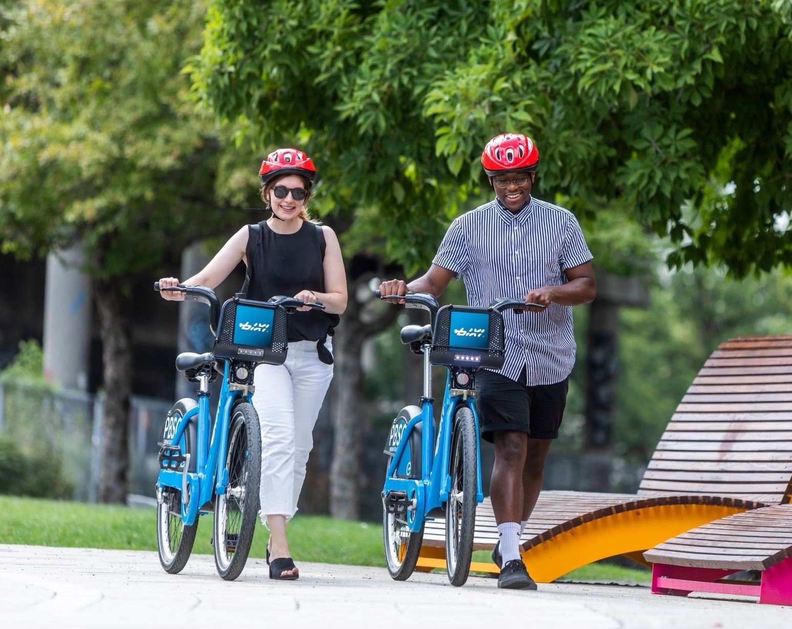 A man and woman ride their BIXI bikes side by side in Montreal