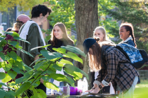 Students convene around a table.