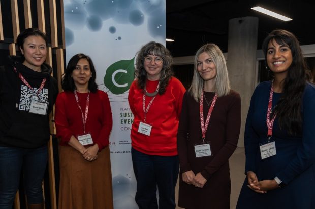 5 women standing together and smiling in front of Sustainable Event certification banner