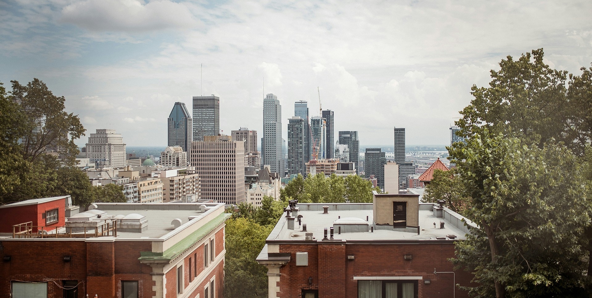 Montreal rooftops and skyline with scattered clouds.