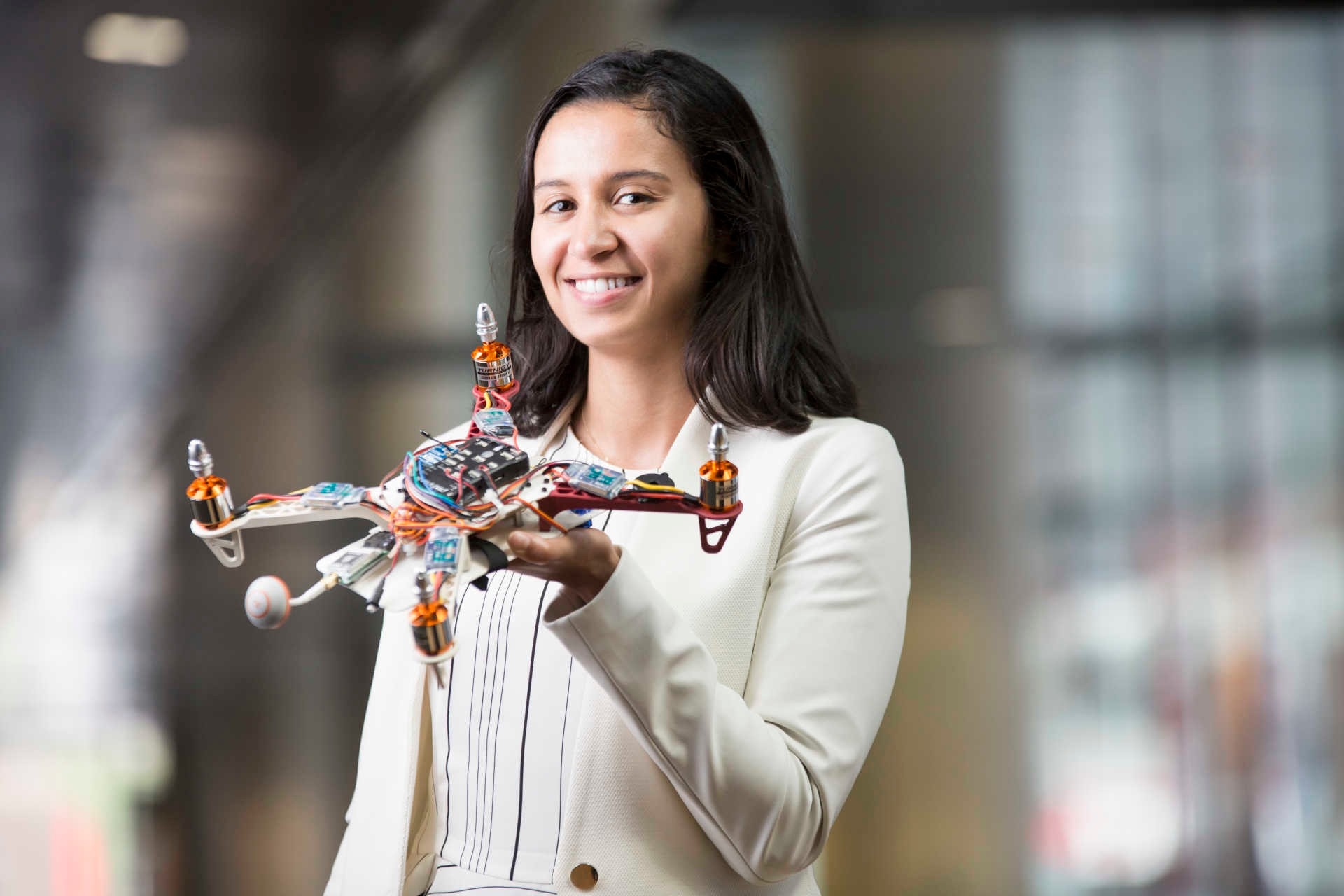 Screenshot of woman holding a drone, cropped to Photo 6:4