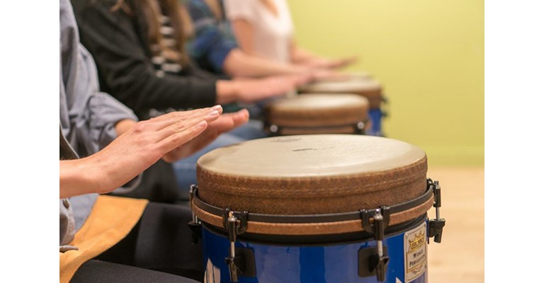 3 sets of hands hitting on bongo drums