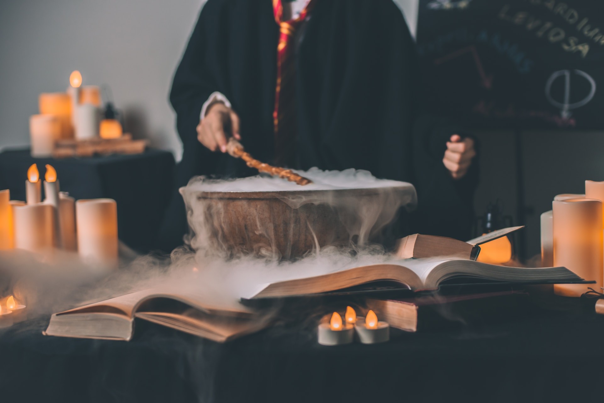 Hand holding a wand over a bowl spilling over with dry ice