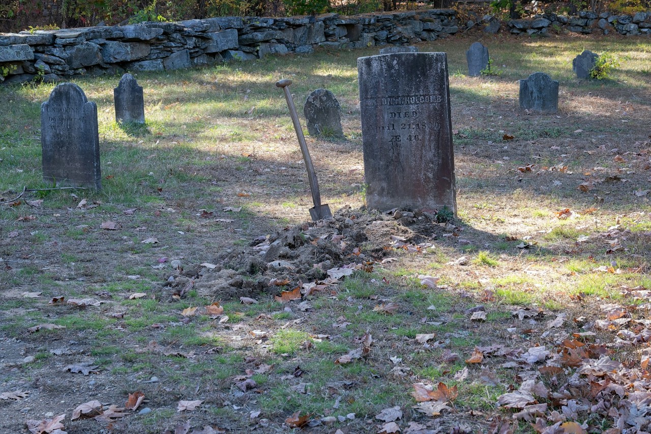 Cemetery grave with fresh earth and shovel