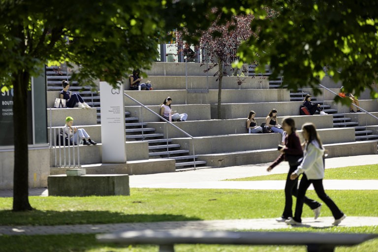 Students walking on the grass in front of the CJ Building
