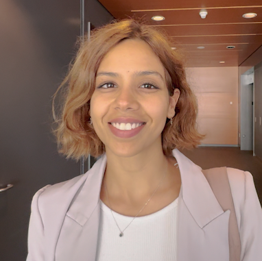 Une femme aux cheveux blonds courts et à la tenue professionnelle regarde la caméra et sourit. Une femme aux cheveux blonds courts et à la tenue professionnelle regarde la caméra et sourit.