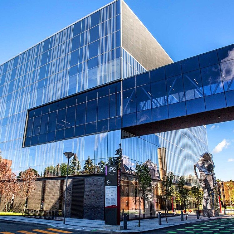 A modern looking building with a reflective exterior on a university campus. A modern looking building with a reflective exterior on a university campus.