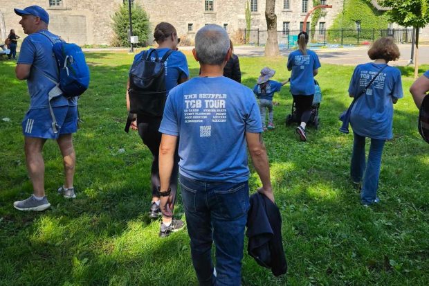 Une équipe de personnes portant des chemises bleues assorties se promène dans le jardin communautaire du pavillon des Sœurs‑Grises sur le campus Sir George Williams de l'Université Concordia.