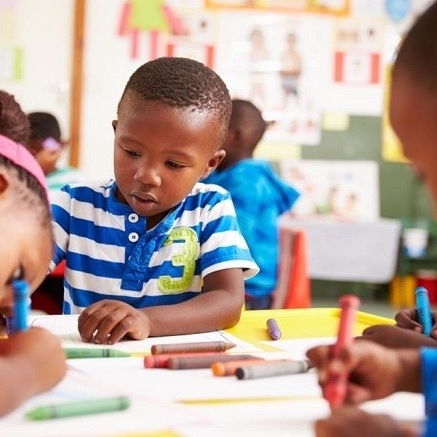 Trois enfants de la communauté noire dessine en classe 