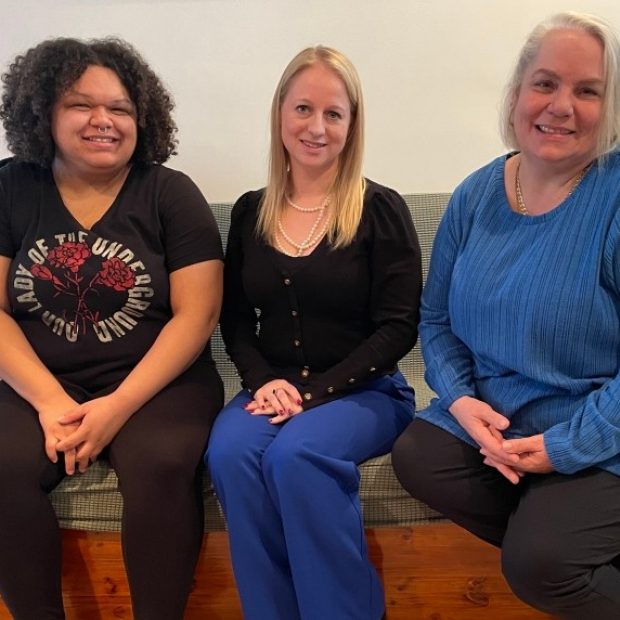 Une photographie de trois membres de l'équipe de la Maison Li-Ber-T souriant directement à l'appareil photo.