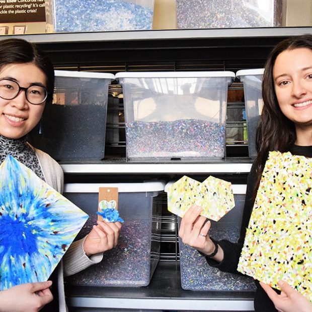 Une photographie de deux personnes brandissant des boucles d'oreilles et des sous-verres fabriqués à partir de plastiques recyclés.