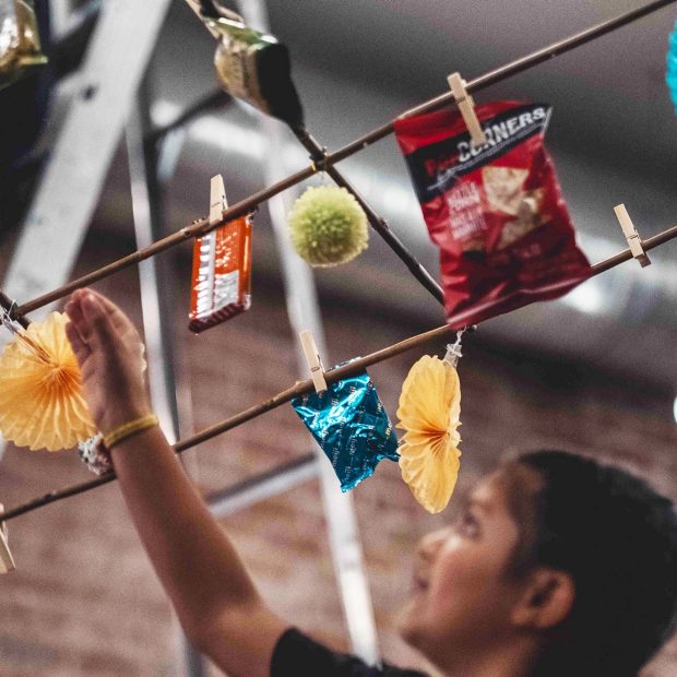 Photographie d'une personne regardant une installation artistique au-dessus d'elle.