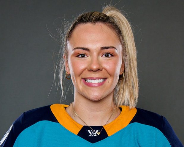 Une femme aux cheveux blonds coiffés en queue de cheval porte un maillot de hockey des Sirens de New York