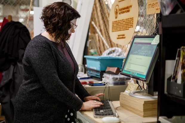 Une personne tapant sur un clavier à un bureau avec un écran d'ordinateur affichant un site web.
